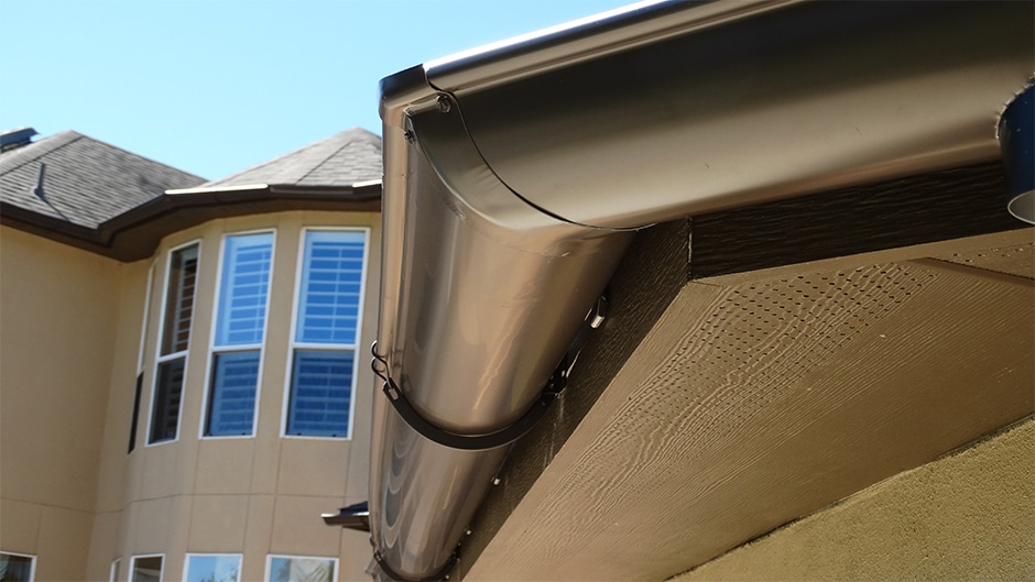 Professional seamless gutter installation on Central Texas home